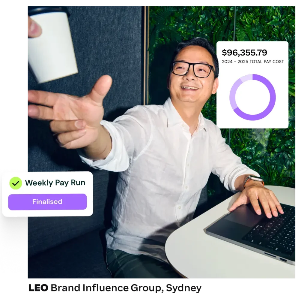 A man smiles and reaches for a takeaway coffee cup at a desk, while payroll summary data and pay run status appear.