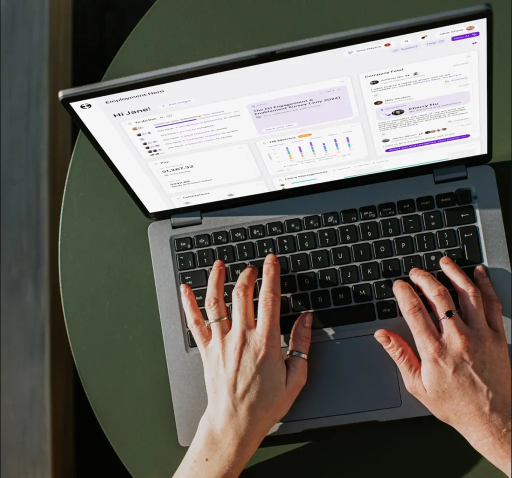 Hands typing on a laptop with a dashboard on screen. The interface displays graphs, text, and notifications, conveying a focused and productive mood.