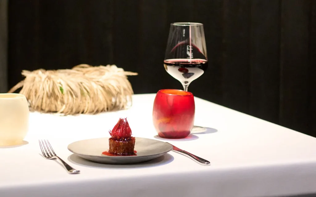 A table set with a dessert and a glass of red wine, creating an elegant dining atmosphere.