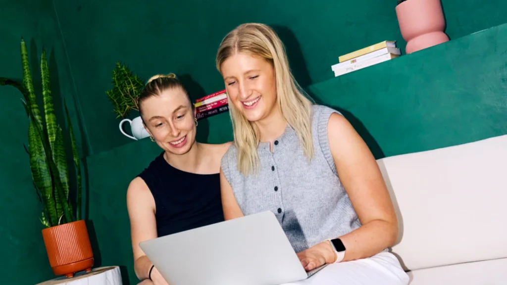 Two women sharing a laptop
