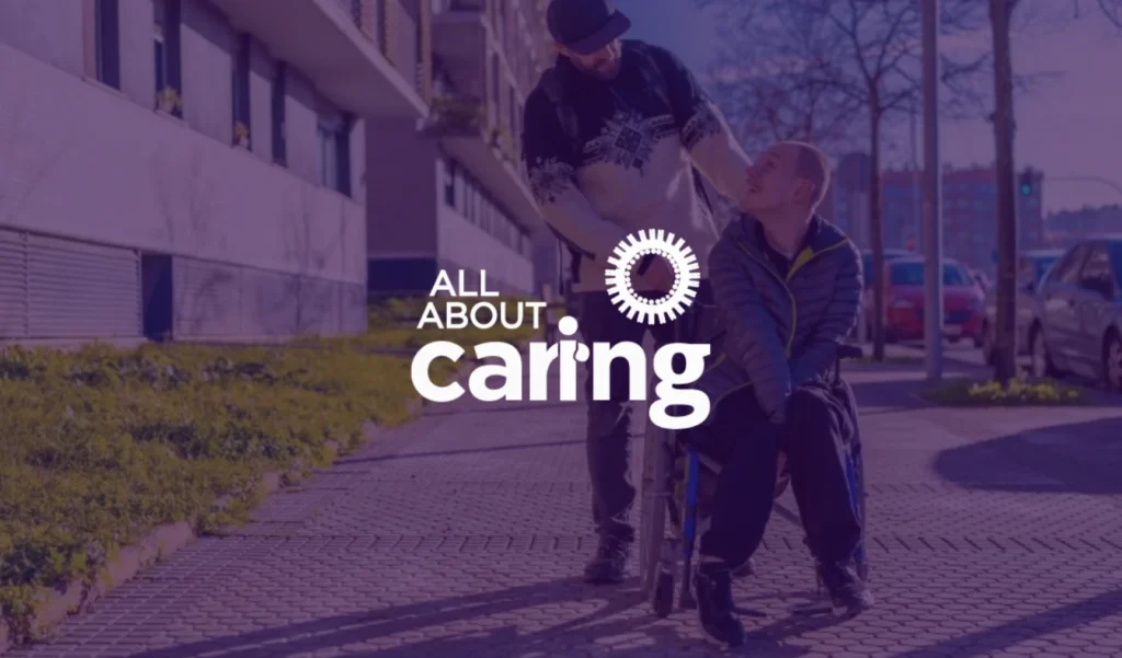 A person in a wheelchair smiles at their caregiver on a sunny sidewalk. Text overlay reads "All About Caring," emphasizing compassion and support.
