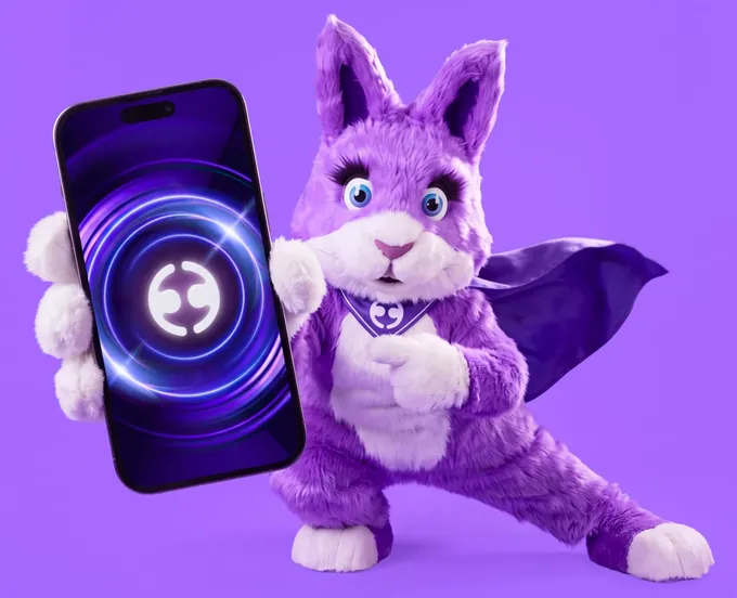 Big Ears, the Employment Hero bunny, holding up a phone with the Employment Hero logo